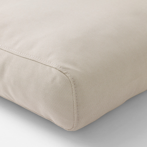 Cojín beige plegado, cuidadosamente cosido, que muestra materiales de calidad y artesanía.