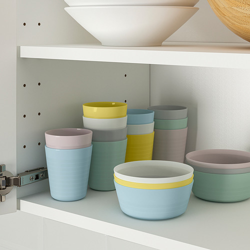 Los coloridos tazones y tazas para niños se apilan ordenadamente para ahorrar espacio, ideales para aprender a comer de forma independiente.
