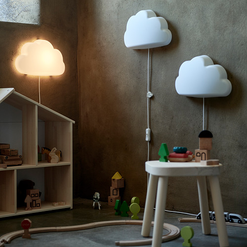 Habitación infantil juguetona con lámparas blancas en forma de nube, una luz suave y brillante, juguetes de madera y una casa de muñecas, creando un ambiente acogedor e imaginativo.