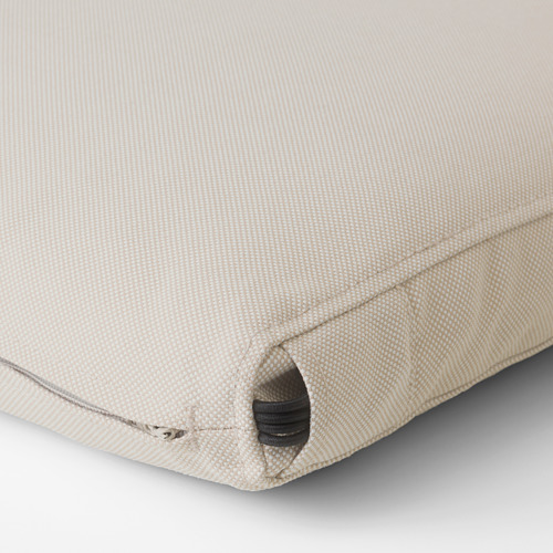 Primer plano de un cojín de exterior beige bien elaborado, con una cremallera resistente y costuras finas, lo que enfatiza su calidad y durabilidad.
