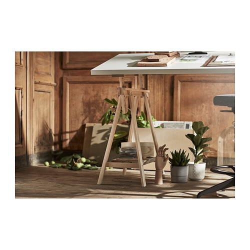 Montaje de escritorio de madera con tablero blanco y patas de color claro. Incluye plantas y papel sobre la mesa.