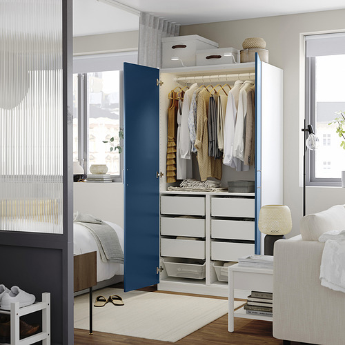 Dormitorio moderno con armario modular blanco y azul y almacenaje.