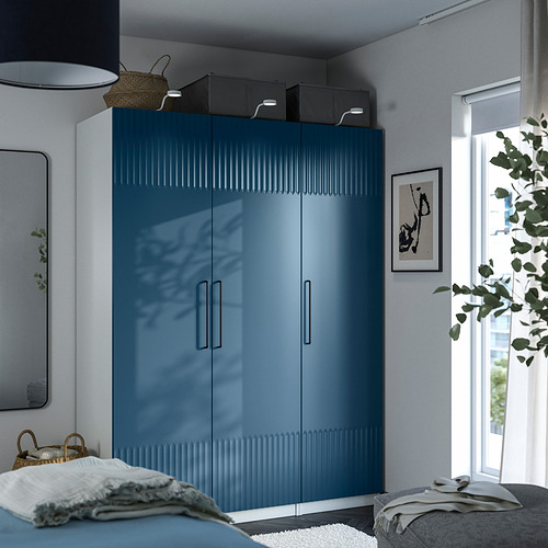 Dormitorio moderno con armario PAX azul, puertas elegantes, manijas metálicas y espejo.