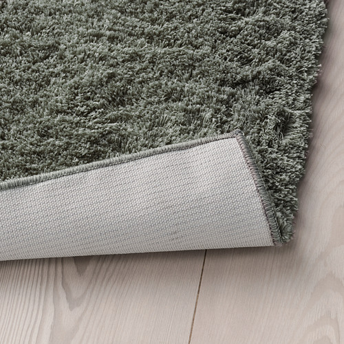 Alfombra de felpa gris sobre suelo de madera, cálida y suave para dormitorios.