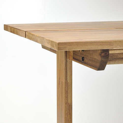 Detalle del borde de la mesa de madera: liso, acabado en acacia, patas robustas.