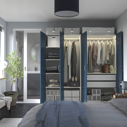 Dormitorio moderno con armario abierto, que muestra ropa, accesorios y almacenamiento organizado. Sistema PAX azul con estantes, cajones y espacio para colgar.