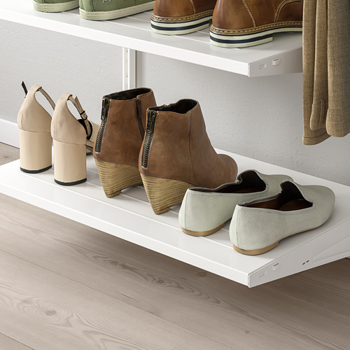 Estanterías blancas de pared para guardar calzado diverso. Las botas marrones con cremallera, los tacones cuadrados beige y los zapatos sin cordones verde claro están perfectamente organizados.