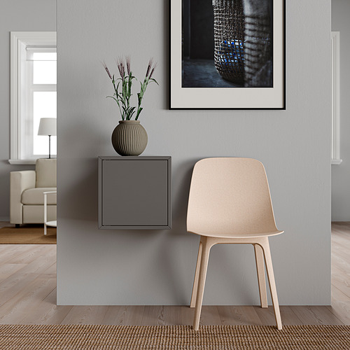 Ambientación minimalista de la habitación: silla de madera clara, estantería EKET gris, jarrón para plantas, impresión artística, suelo claro.