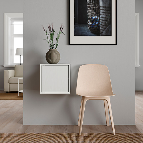 Habitación minimalista con armario de pared, silla de madera, jarrón de plantas, arte abstracto y alfombra.