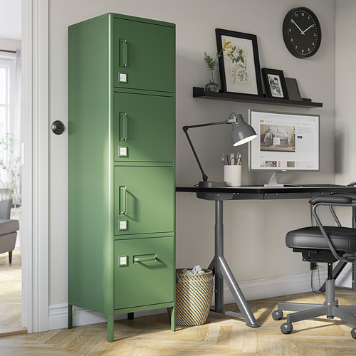 Taquilla IDÅSEN verde oliva junto al escritorio de la oficina en casa, alta con múltiples compartimentos y detalles plateados.