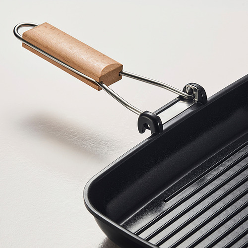 Sartén parrilla moderna con mango de madera, superficie antiadherente, apoyada sobre superficie lisa.