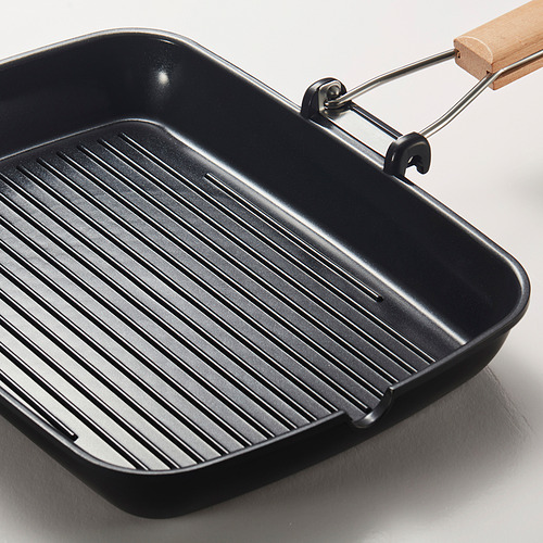 Sartén grill negra con mango de madera, superficie acanalada para una cocción uniforme, diseñada para todo tipo de estufas.