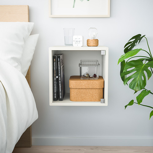 Estante de cubo EKET blanco montado en la pared que almacena libros, plantas, caja de corcho y artículos decorativos.