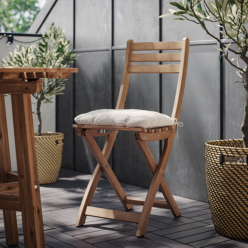 Escena exterior con silla y cojín de madera ASKHOLMEN, beige claro.