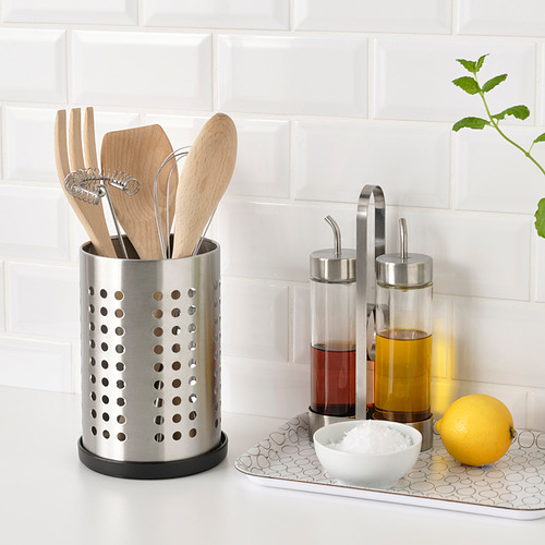 Encimera de cocina con utensilios de madera, dispensadores de aceite, limón, sal, y bandeja bajo portautensilios para drenar el agua.