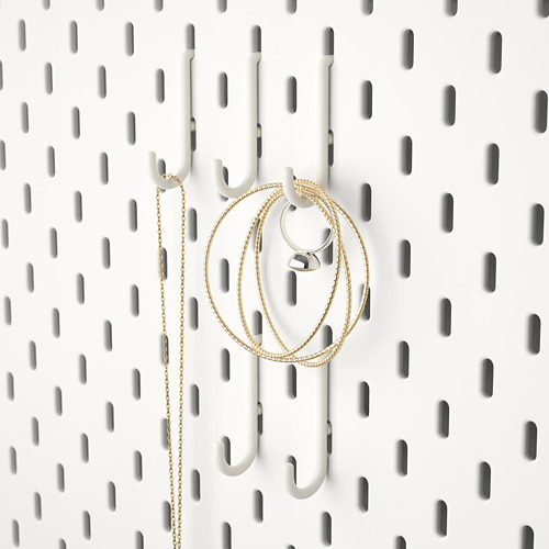 Tablero perforado blanco con ganchos que sujetan artículos de cadena de oro, ideal para organizar accesorios como joyas o llaves.
