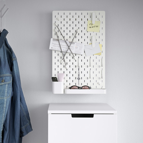 Tablero perforado SKÅDIS blanco con accesorios y chaqueta vaquera. Organiza objetos pequeños como llaves, notas y mucho más.
