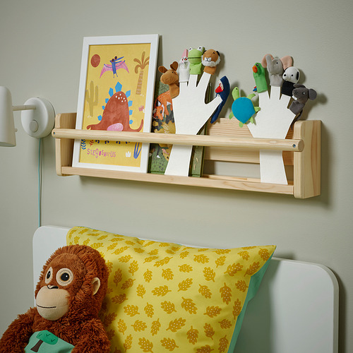 Estantería de madera con libros, títeres y juguetes infantiles encima de la cama.