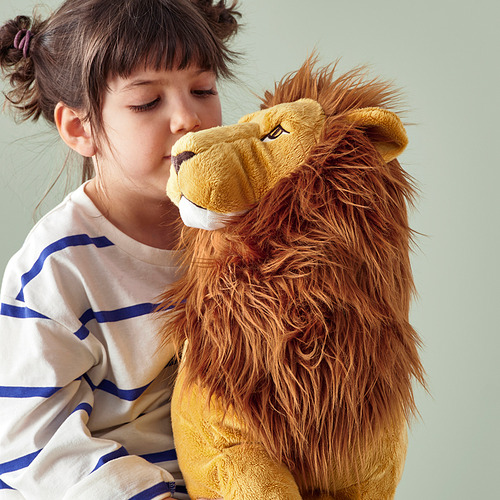 La niña abraza un gran juguete de león de peluche, ambos brindan consuelo y compañía.