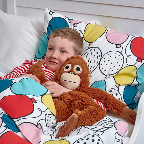 Un niño abraza a un mono de peluche, que se puede usar para colgar en una mochila, demostrando su diseño funcional.