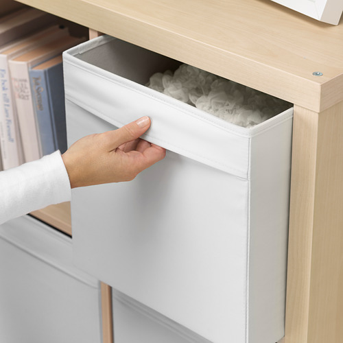 La mano saca la caja de almacenamiento DRÖNA blanca de la estantería, revelando su contenido.
