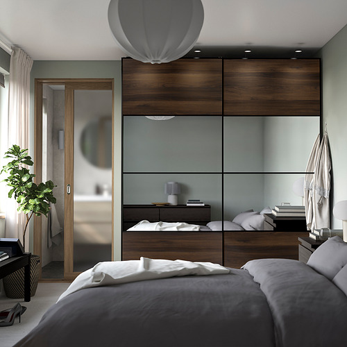 Dormitorio elegante con puerta corredera AULI con espejo y armario de almacenamiento.