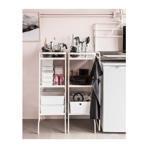 Rincón de cocina moderno: el estante blanco SUNNERSTA contiene platos negros, tazas, frascos de vidrio y botellas rosas.