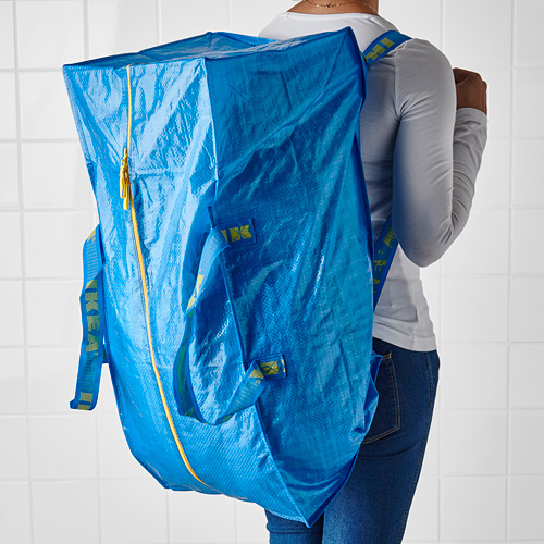 Persona que lleva una bolsa azul de ikea FRAKTA al hombro.