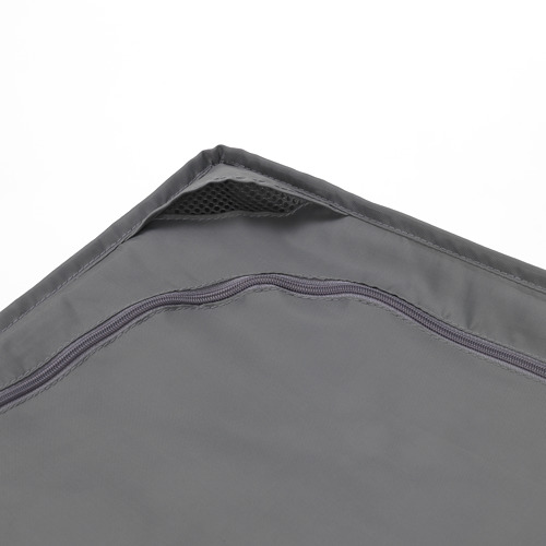 Detalle de esquina de bolso de tela gris, con costuras resistentes y cremalleras de calidad.