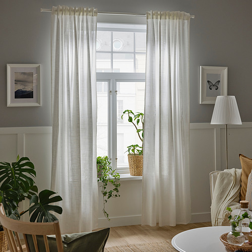Cortinas blancas transparentes al lado de la ventana para una privacidad ligera.