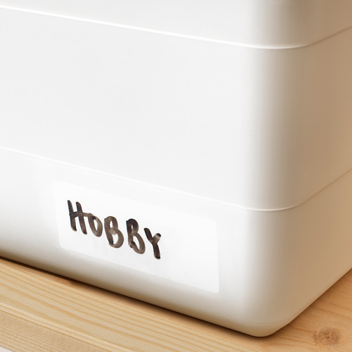 Una caja de almacenamiento blanca con tapa a presión, etiquetada con hobby, ideal para organizar artículos y mantener el polvo fuera.