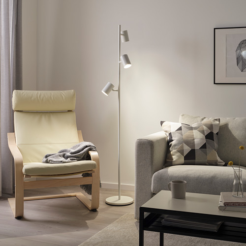 Salón moderno con lámpara NYMÅNE, mecedora, sofá, mesa de centro.