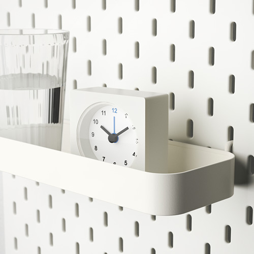 Estantería SKÅDIS blanca con reloj y cristal. Mantiene los elementos organizados y el tiempo mostrado.