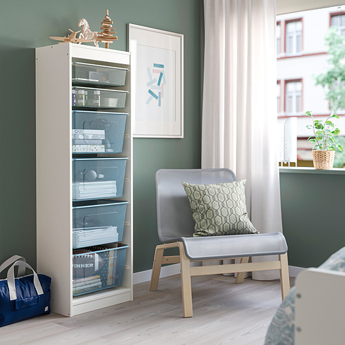 Mueble de almacenaje TROFAST blanco junto a una silla gris.