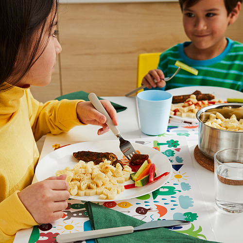 Niños comiendo comida colorida, uno en amarillo, otro en camisa a rayas verdes.