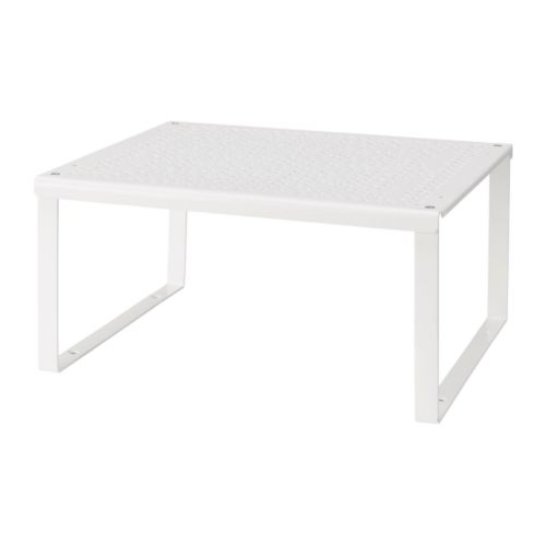 Un inserto de estante VARIERA blanco. Es de forma cuadrada con la parte superior perforada, sostenida por cuatro patas metálicas.