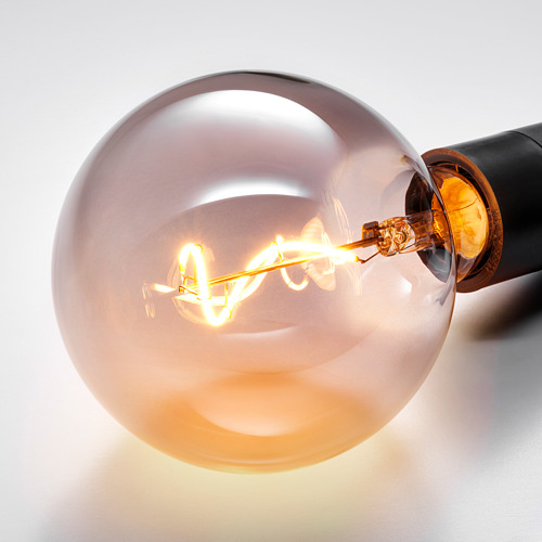 Bombilla led con filamento en espiral dentro de vidrio esmerilado, encendido, resplandor cálido.