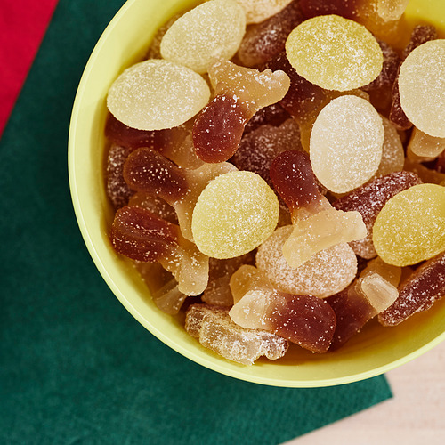 Tazón de caramelos azucarados mezclados: redondos, barcos vikingos y alces, en marrón y amarillo, espolvoreados con azúcar.