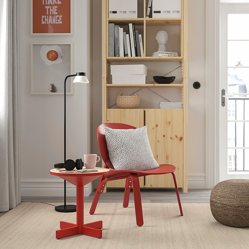 Mesa auxiliar grimsaebo de estilo escandinavo rojo brillante junto a una silla roja. Pequeño, moderno, de metal y madera, encaja perfectamente junto a los muebles.