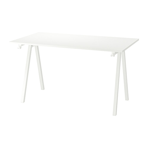 Un escritorio TROTTEN blanco. Es rectangular, sostenido por patas angulares de metal blanco, y tiene un diseño limpio y minimalista.