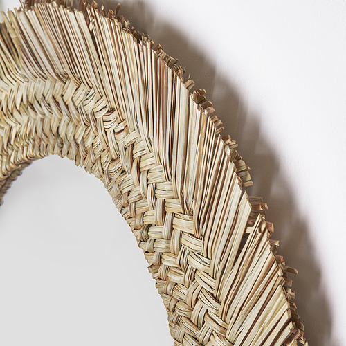 Espejo con marco de junco natural tejido a mano. Diseño intrincado y artesanal con tonos claros y terrosos.
