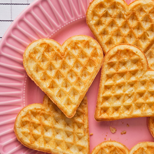 Gofres en forma de corazón, crujientes por fuera, suaves por dentro. Servido con mermelada, crema o salmón. Perfecto para postre o aperitivos.