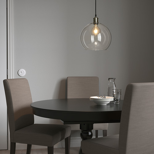 Lámpara colgante JAKOBSBYN sobre mesa de comedor con cuenco y jarra, sillas grises.