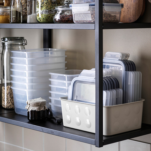 Estantería con recipientes de plástico transparente IKEA 365+ en varios tamaños, con las tapas almacenadas verticalmente.