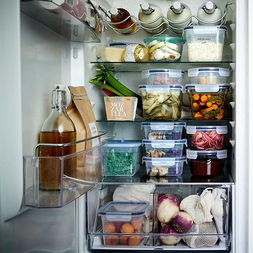 Nevera bien organizada con contenedores IKEA 365+ que almacenan varios alimentos, manteniendo los artículos frescos y visibles.