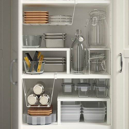Gabinete de cocina con recipientes transparentes, acero inoxidable, tablas de madera y frascos de vidrio cuidadosamente organizados.
