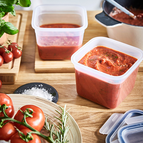 Varios recipientes de plástico que almacenan salsa de tomate y tomates frescos, ideales para conservar las sobras de manera eficiente.