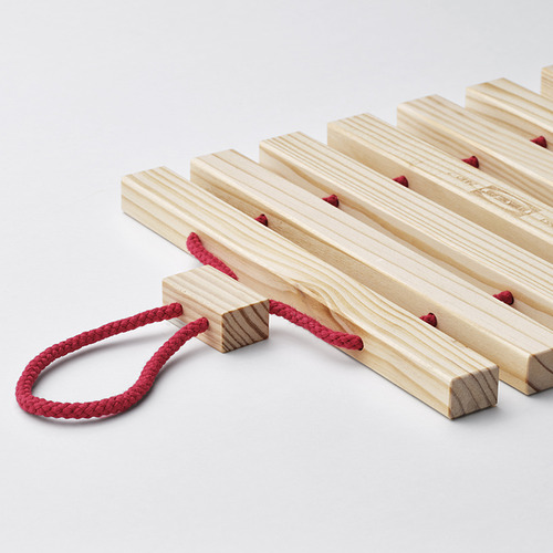 Soporte de cuerda roja sobre superficie blanca.