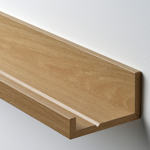 Estantería de pared de madera, de una sola pieza, acabado claro, montada sobre pared blanca, con un diseño sencillo y moderno.