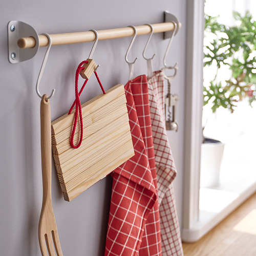 Organizador de cocina con ganchos que sostienen tablas de cortar de madera, toallas a cuadros rojos y utensilios de cocina.